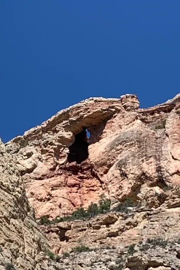 Mv Belle Yacht Photos Pics Rock formation with natural arch under clear blue sky.