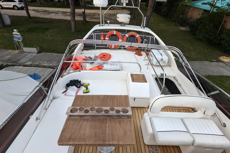  Yacht Photos Pics 1998 Princess 52 Flybridge Motor Yacht deck with seating, table, and safety equipment.