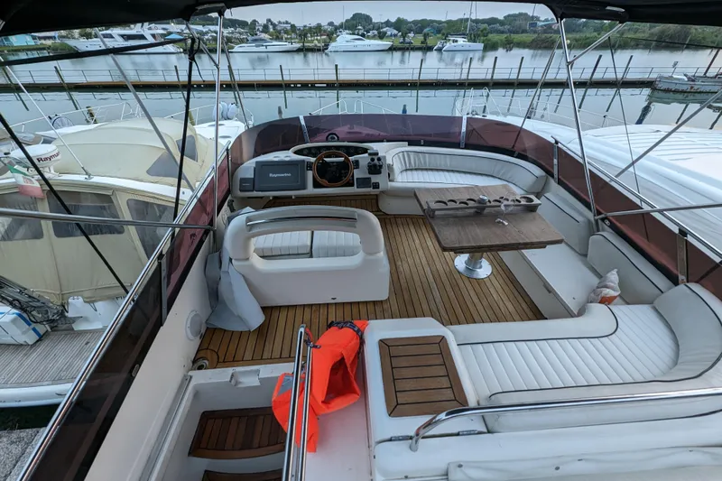  Yacht Photos Pics Flybridge of 1998 Princess 52 Yacht with seating, table, and marina view.