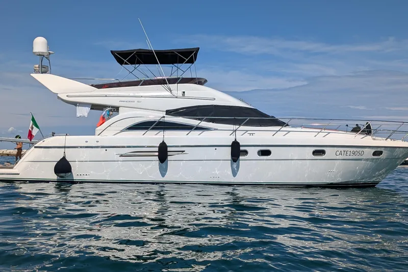  Yacht Photos Pics 1998 Princess 52 Flybridge Motor Yacht on calm water, side view.
