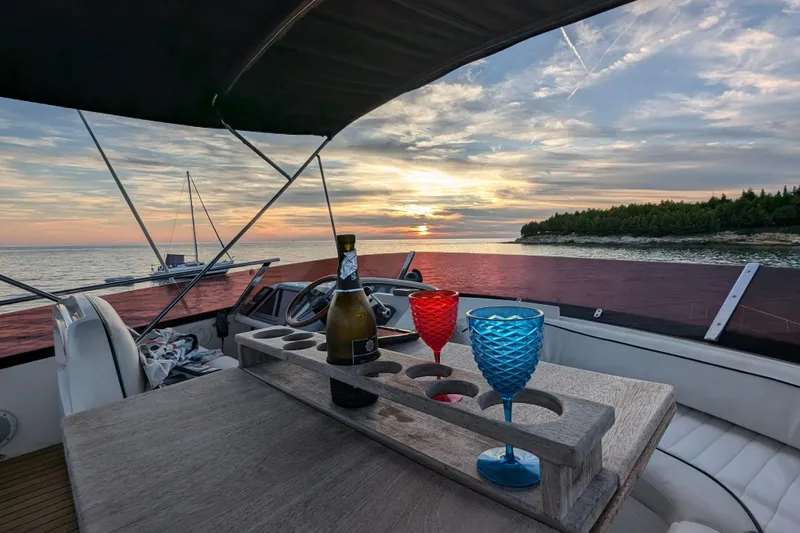  Yacht Photos Pics 1998 Princess 52 Flybridge Motor Yacht at sunset with wine glasses and bottle.