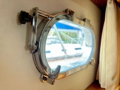  Yacht Photos Pics Porthole view from a 2001 Apreamare 12m yacht, showcasing exterior marina scene.