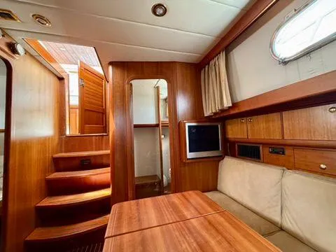  Yacht Photos Pics Interior of 2001 Apreamare 12m yacht with wooden finishes and cozy seating area.