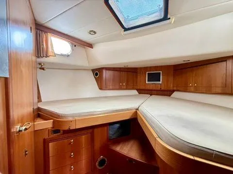  Yacht Photos Pics Interior cabin of 2001 Apreamare 12m yacht with wooden furnishings and bedding.
