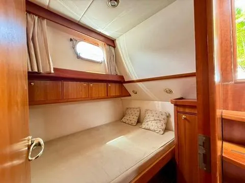  Yacht Photos Pics Cozy cabin interior of 2001 Apreamare 12m yacht with wooden accents and comfortable bedding.
