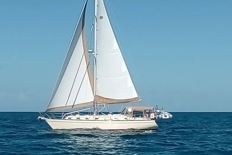 Petrel Yacht Photos Pics Sailing yacht Island Packet 420, 2001 model, cruising on open sea under clear blue sky.