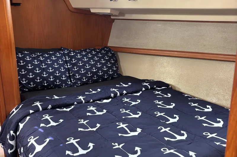 Petrel Yacht Photos Pics Cozy cabin bed with anchor-themed bedding on a 2001 Island Packet 420 sailboat.