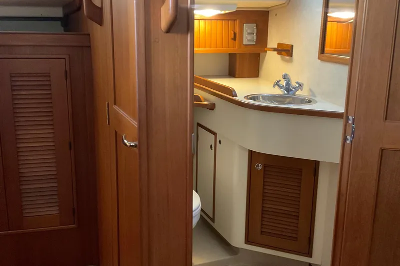 Petrel Yacht Photos Pics Interior of 2001 Island Packet 420 yacht, featuring wooden cabinetry and compact bathroom.