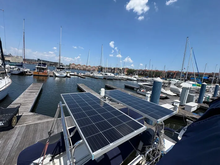 Ventosa Yacht Photos Pics Catalina 350 sailboat with solar panels docked at a marina, clear sky background.