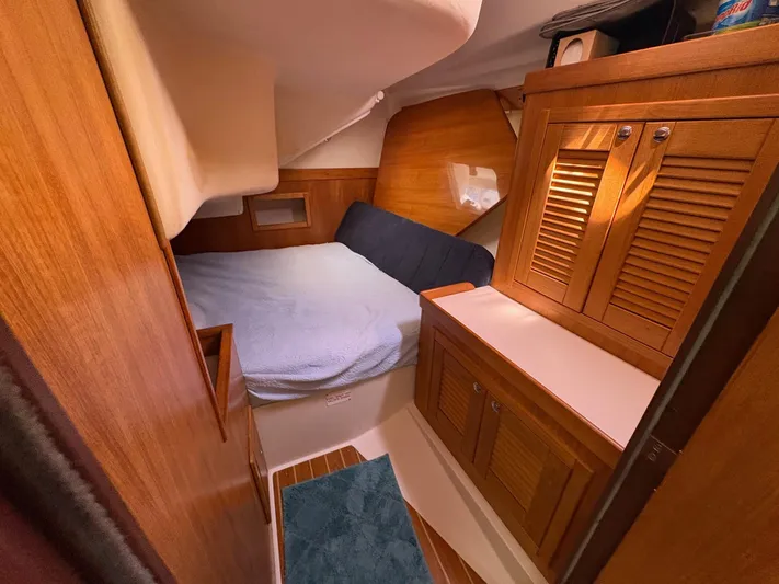 Ventosa Yacht Photos Pics Cozy cabin interior of a 2006 Catalina 350 sailboat with wooden cabinetry and a comfortable bed.