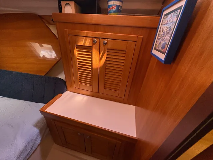 Ventosa Yacht Photos Pics Wooden interior of a 2006 Catalina 350 sailboat with cabinets and framed artwork.