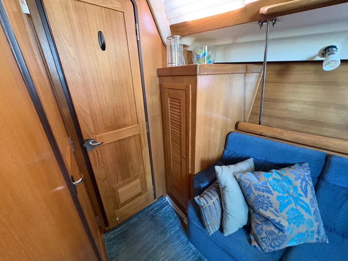 Ventosa Yacht Photos Pics Interior of 2006 Catalina 350 sailboat with wooden cabinetry and blue cushioned seating.