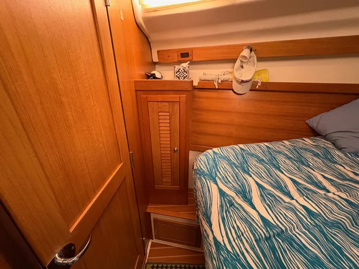 Ventosa Yacht Photos Pics Cozy cabin interior of 2006 Catalina 350 sailboat with wooden cabinetry and patterned bedding.