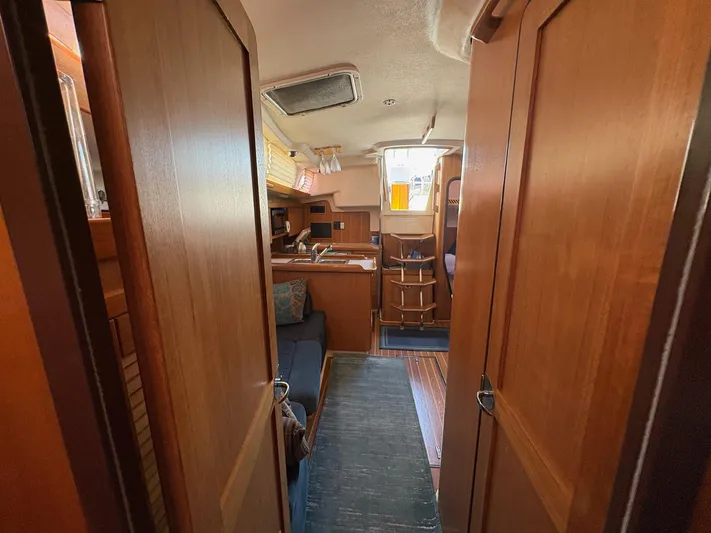 Ventosa Yacht Photos Pics Interior of a 2006 Catalina 350 sailboat, featuring wooden cabinetry and cozy seating.
