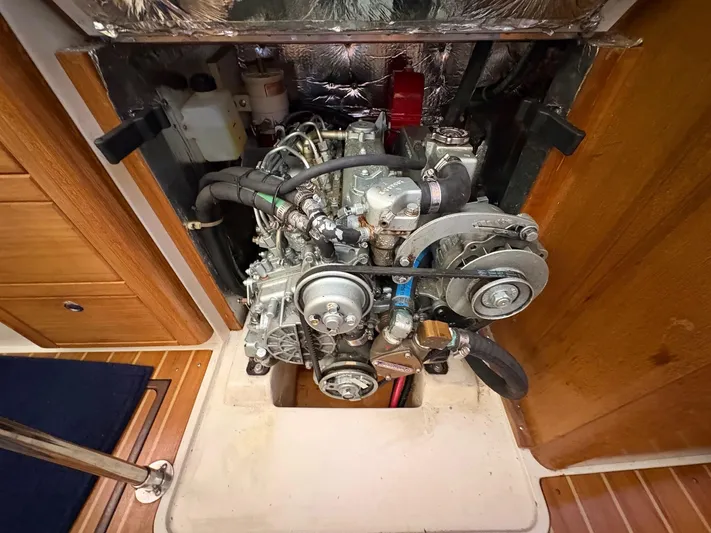 Ventosa Yacht Photos Pics Engine compartment of a 2006 Catalina 350 sailboat, showcasing mechanical components and wooden interior.