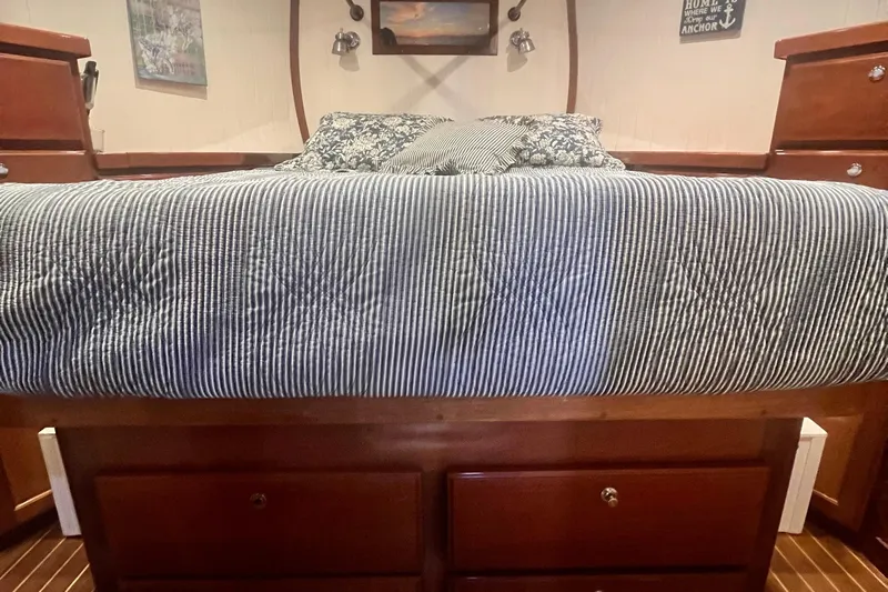 Insandity Yacht Photos Pics Cozy bedroom interior of 2006 Great Harbour N37 boat with striped bedding and wooden storage.