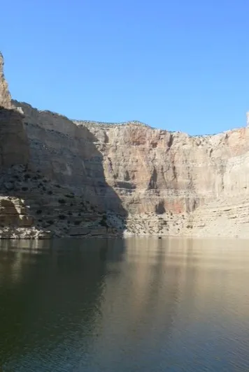 Mv Belle Yacht Photos Pics Scenic canyon view with calm water and rocky cliffs under a clear blue sky.