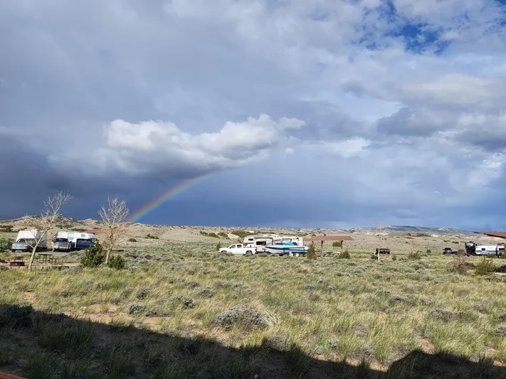 Mv Belle Yacht Photos Pics Tour boat and business vehicles under a rainbow in a vast grassy landscape, 1987 Custom model.