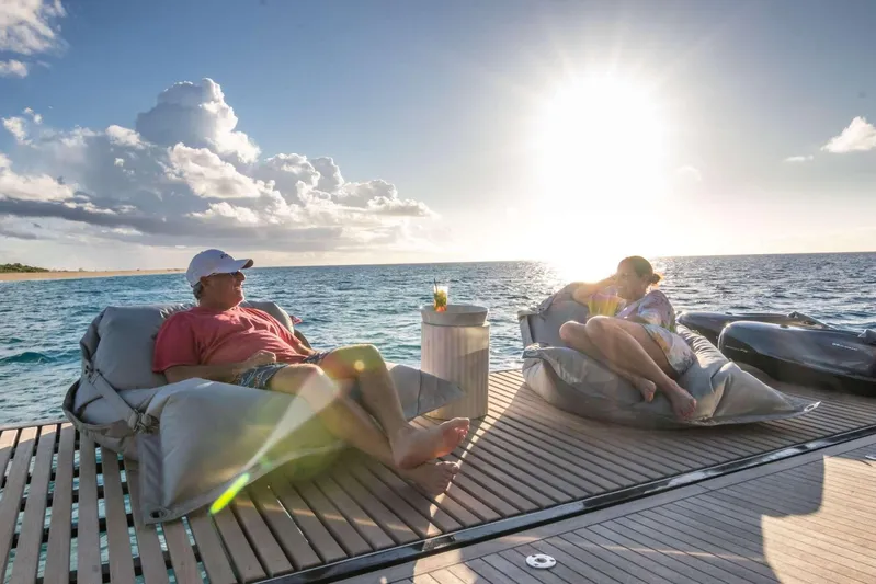Relentless Yacht Photos Pics Couple relaxing on Sunreef Sail 60 yacht deck at sunset, 2020 model.