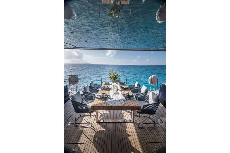 Relentless Yacht Photos Pics Luxurious dining setup on Sunreef Sail 60 yacht, overlooking serene ocean view.