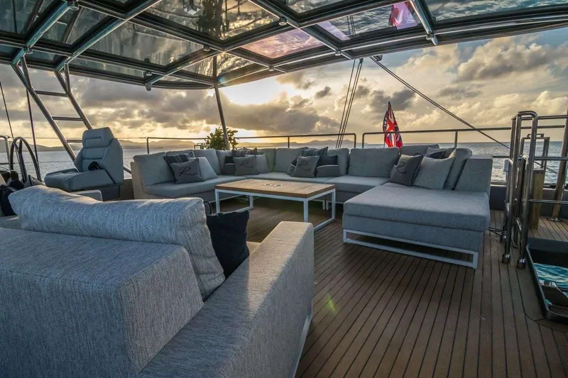 Relentless Yacht Photos Pics Luxurious Sunreef Sail 60 yacht deck with elegant seating, ocean view, and sunset ambiance.
