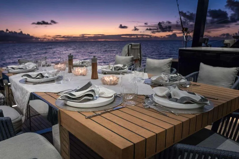 Relentless Yacht Photos Pics Elegant dining setup on Sunreef Sail 60 yacht at sunset, 2020 model.