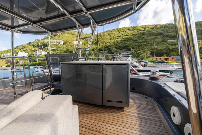 Relentless Yacht Photos Pics Luxurious Sunreef Sail 60 yacht deck with modern amenities, docked in a scenic marina.