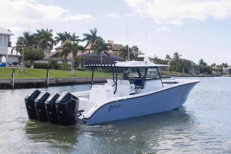  Yacht Photos Pics 2026 Yellowfin 42 Offshore boat cruising on a scenic waterway with palm trees.