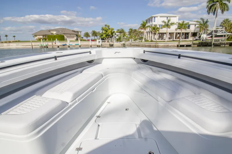  Yacht Photos Pics 2026 Yellowfin 42 Offshore boat interior with white seating, docked near waterfront homes.
