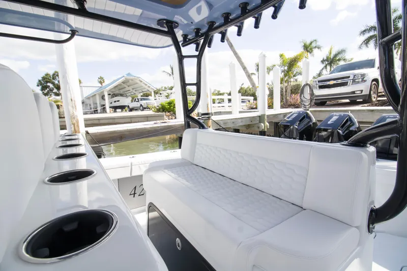  Yacht Photos Pics 2026 Yellowfin 42 Offshore boat interior with white seating and cup holders at a marina.