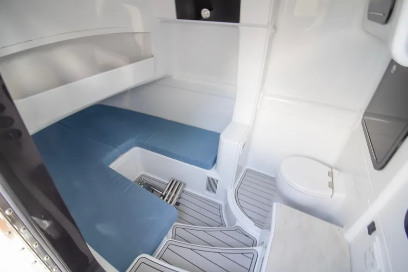  Yacht Photos Pics 2026 Yellowfin 42 Offshore cabin interior with blue seating and compact toilet.