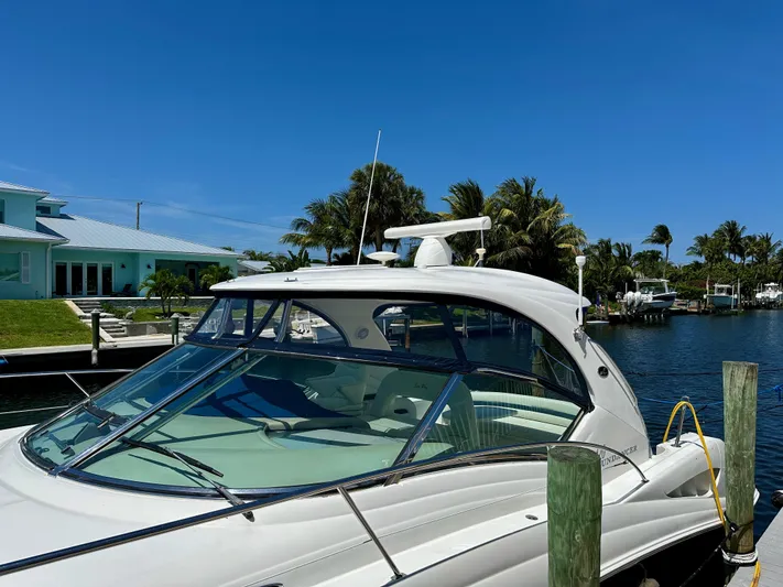 Alibi Yacht Photos Pics 2004 Sea Ray 420 Sundancer yacht docked by a waterfront home under clear blue skies.
