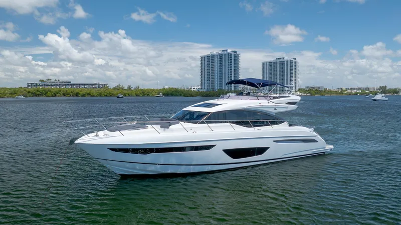  Yacht Photos Pics Luxurious 2017 Princess S65 yacht cruising on a sunny day with cityscape backdrop.