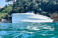 2024 Solaris Power 40 Open yacht on clear blue water near lush coastline.
