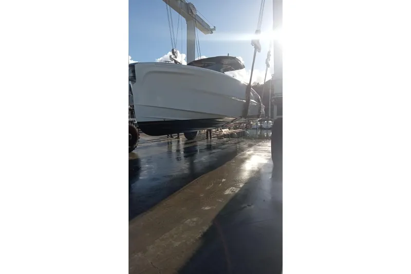  Yacht Photos Pics 2024 Solaris Power 40 Open yacht being lifted at a marina under bright sunlight.