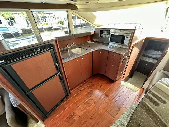 Dolce Far Niente Yacht Photos Pics 2013 Meridian 441 Sedan yacht kitchen with wood flooring, sink, microwave, and refrigerator.