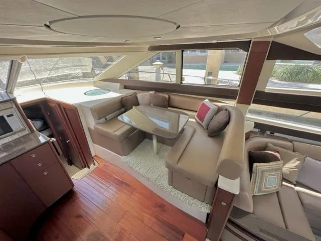 Dolce Far Niente Yacht Photos Pics Luxurious interior of a 2013 Meridian 441 Sedan yacht with plush seating and wooden flooring.