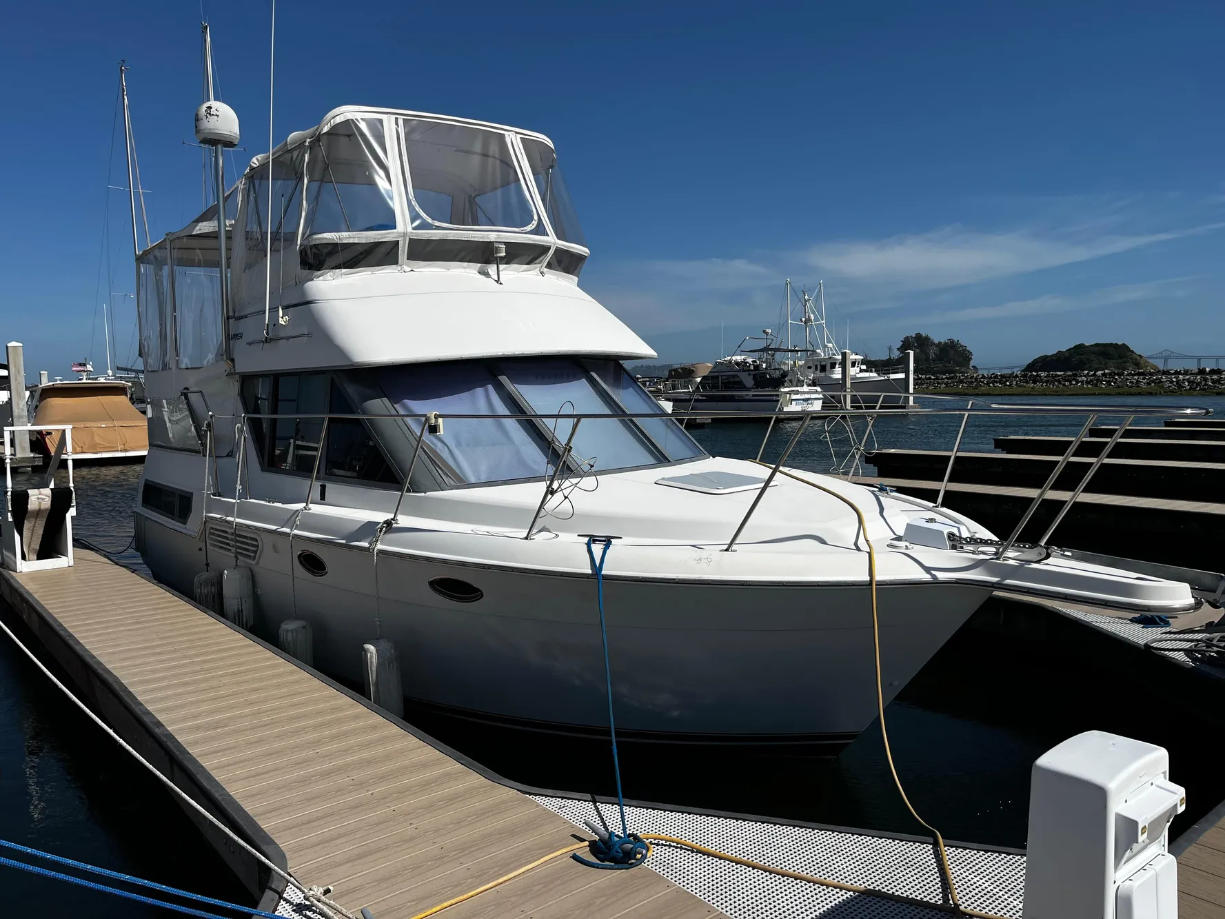 1996 Carver 325 Aft Cabin yacht docked at marina under clear blue sky.