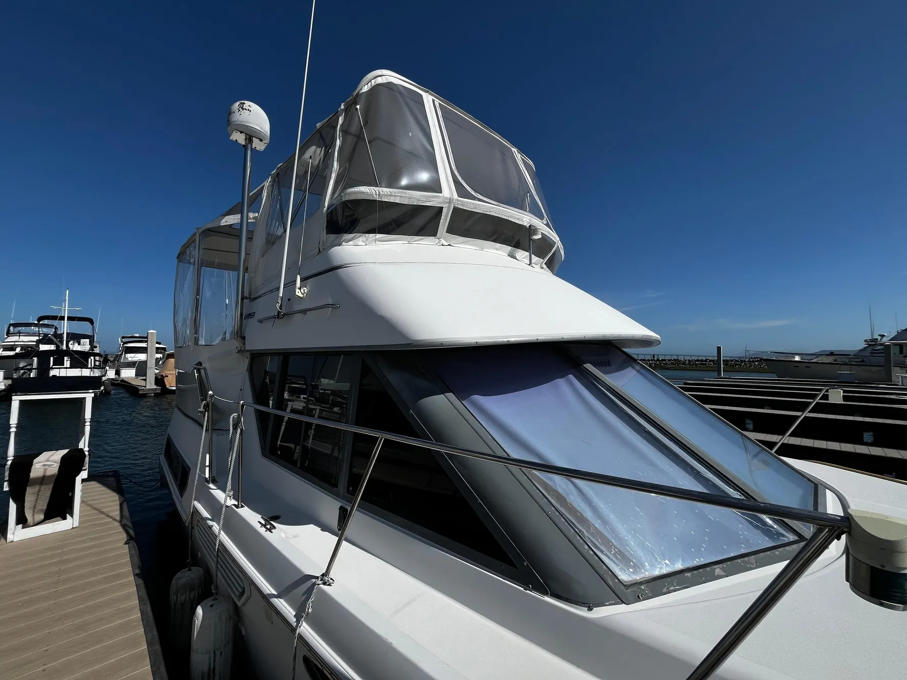 1996 Carver 325 Aft Cabin yacht docked at marina under clear blue sky.