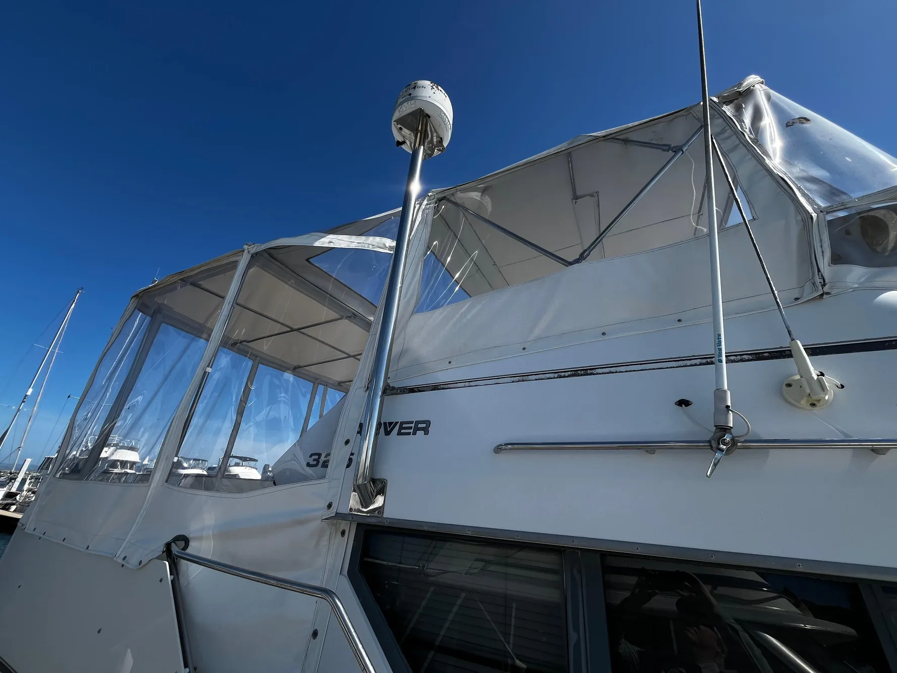 1996 Carver 325 Aft Cabin yacht with clear canopy under blue sky.