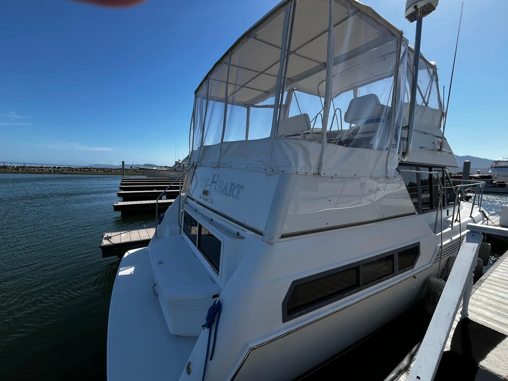 1996 Carver 325 Aft Cabin yacht docked at marina under clear blue sky.