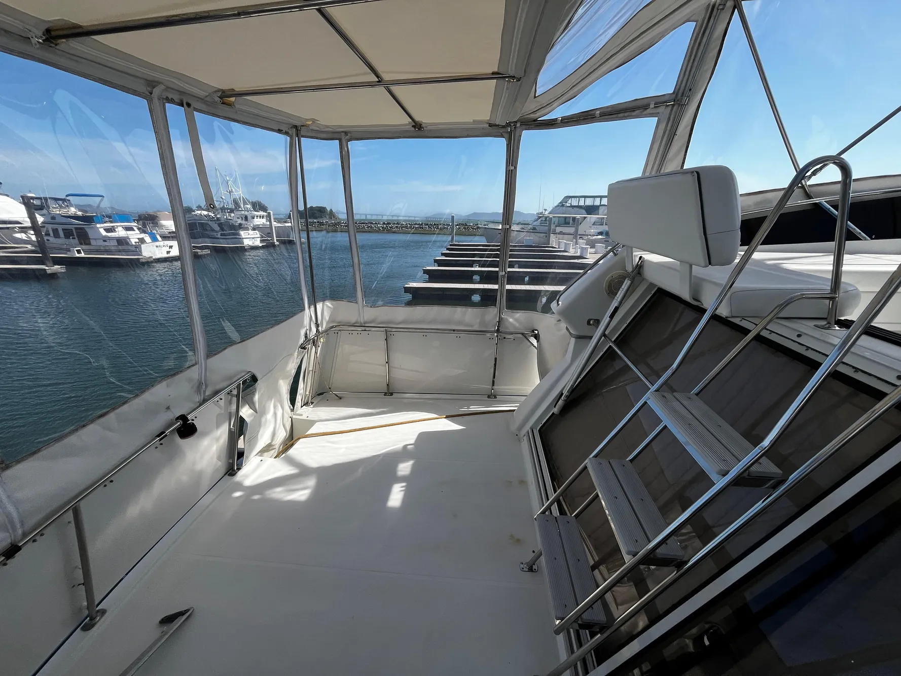 1996 Carver 325 Aft Cabin yacht interior with marina view, featuring spacious deck and seating.