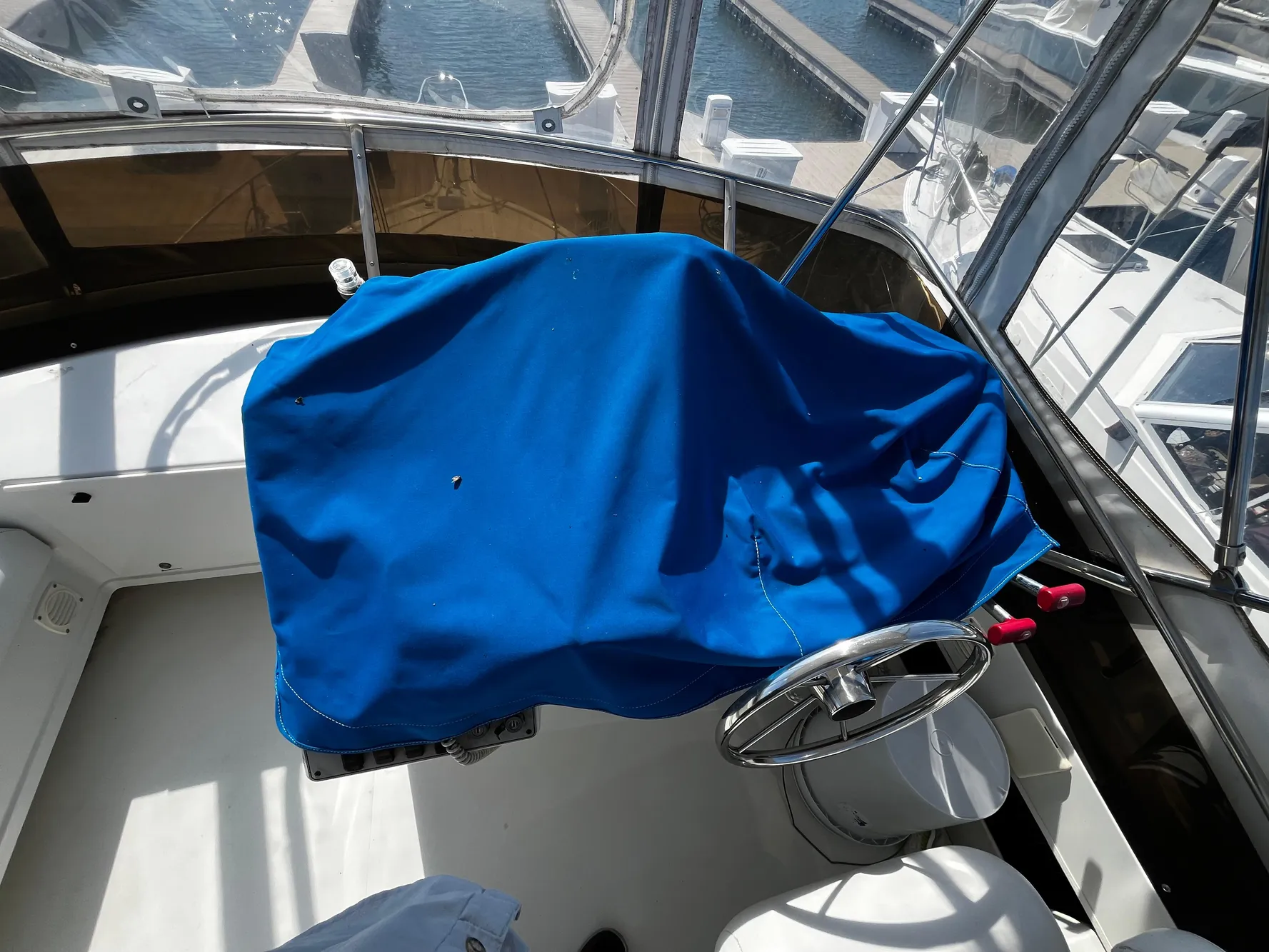 1996 Carver 325 Aft Cabin helm with blue cover, docked at marina.