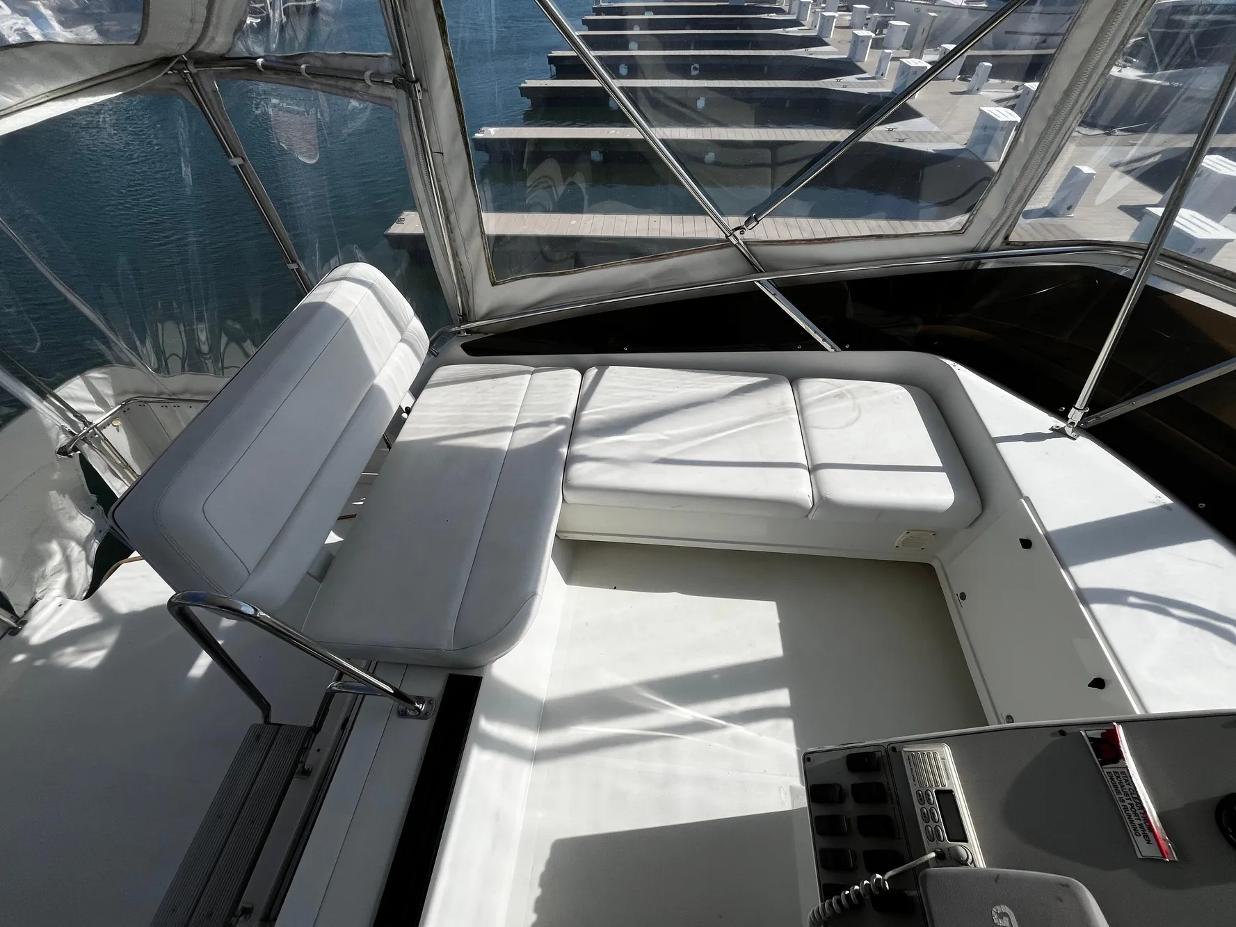 1996 Carver 325 Aft Cabin interior with white seating and marina view.