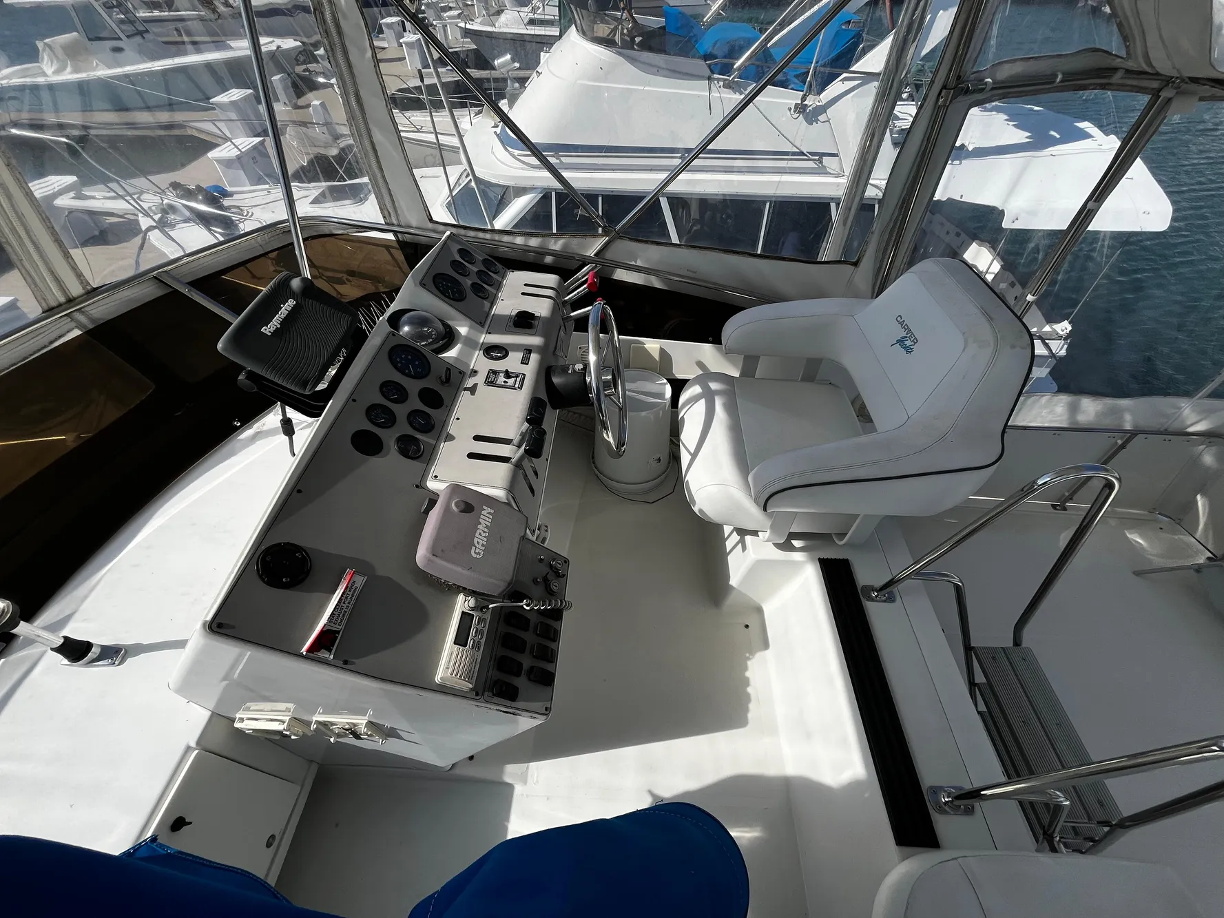 1996 Carver 325 Aft Cabin helm with steering wheel and control panel, docked at marina.