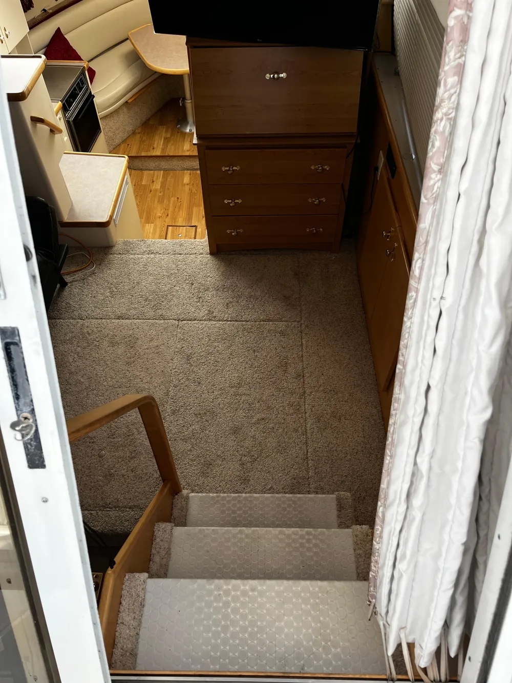 Interior of 1996 Carver 325 Aft Cabin with carpeted stairs and wooden cabinetry.