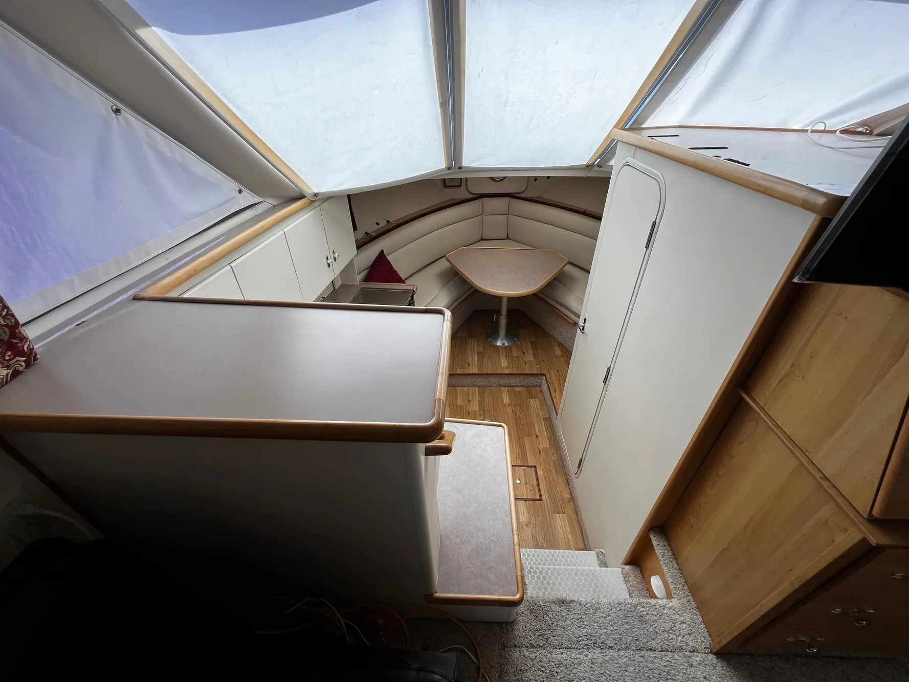 Interior of 1996 Carver 325 Aft Cabin with seating and table, featuring wood accents.