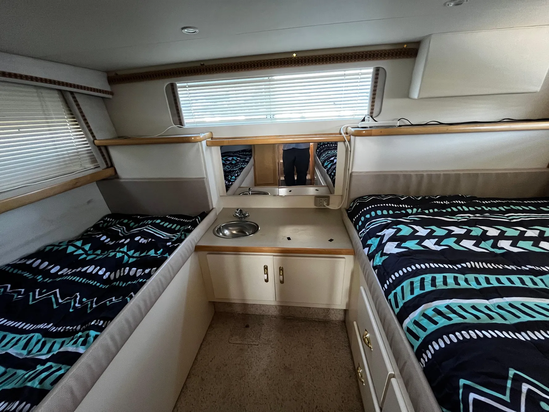 1996 Carver 325 Aft Cabin interior with twin beds and compact kitchenette.