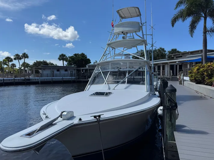 Debaitable Yacht Photos Pics 2004 Albemarle 320 Express Fisherman docked by palm trees under a clear blue sky.