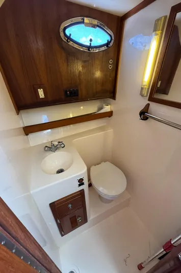 Debaitable Yacht Photos Pics Compact bathroom in 2004 Albemarle 320 Express Fisherman boat with sink, toilet, and porthole.